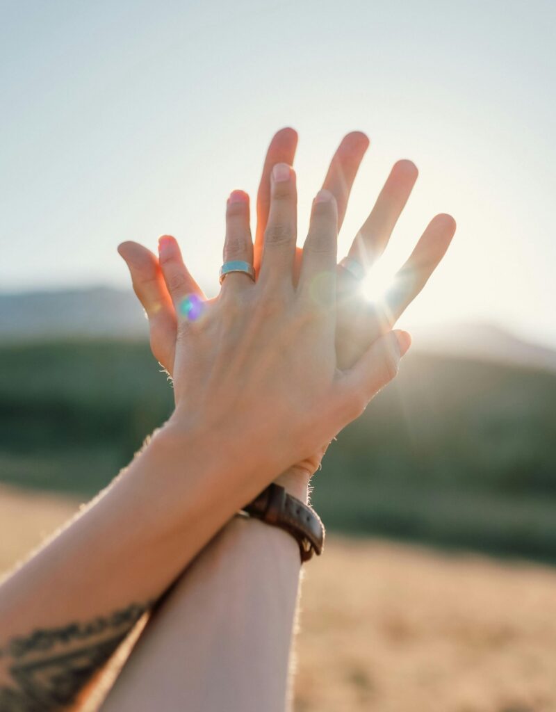 second shooter digital couple holding hands with the sun and a field in the background