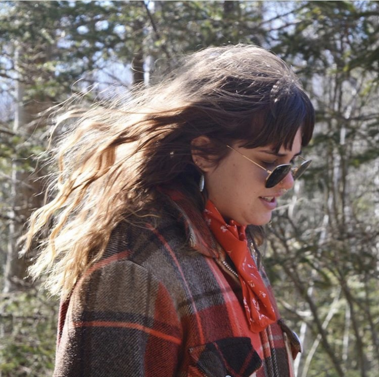 cori wearing a flannel and sunglasses with wind in her hair, co founder and ceo of second shooter digital, an seo agency for wedding photographers